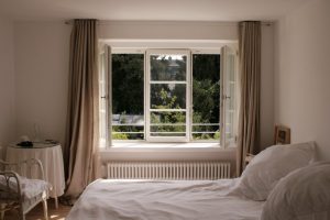 Blick aus dem Schlafzimmer ins Grüne durch ein Berliner Sprossenfenster von frovin