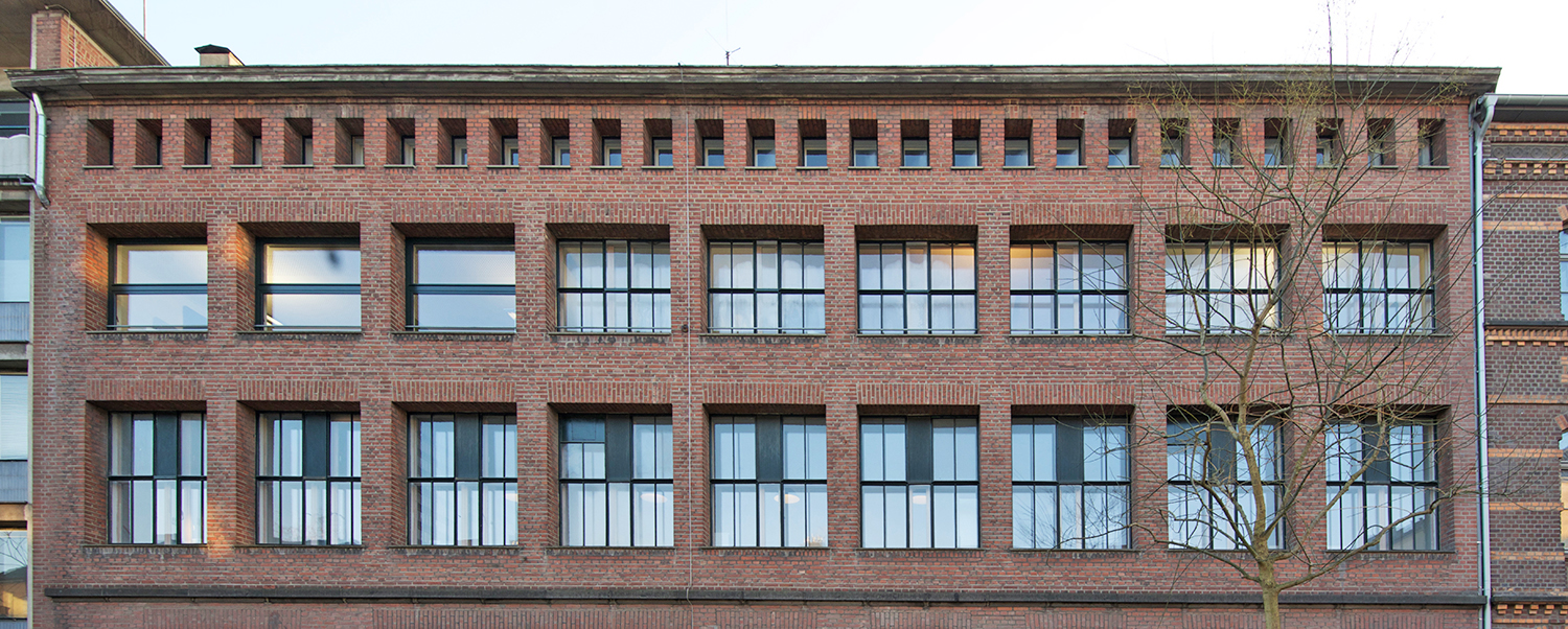 Alte Fabrik aus Backstein mit zwei Reihen doppelflügligen Hinterbau-Fenstern